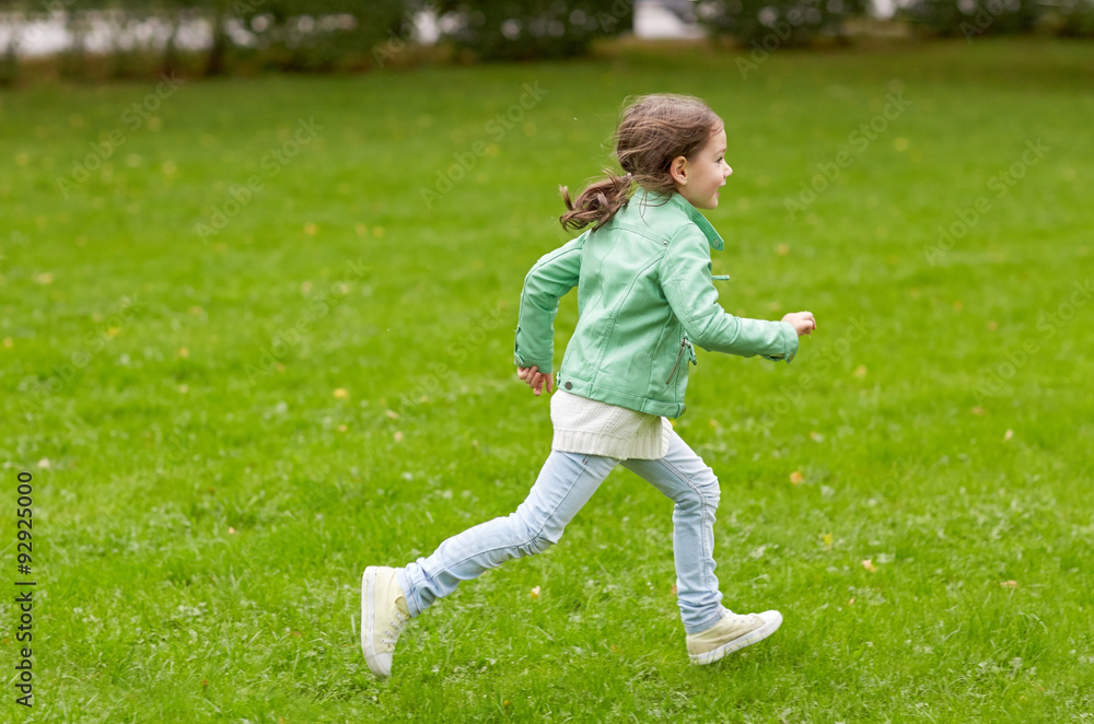 Wall mural happy little girl running on green summer field