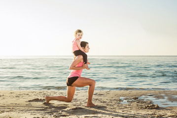 Fototapeta na wymiar family workout - mother and daughter doing exercises on beach. 