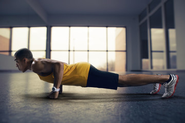 Sport. Young athletic man doing push-ups. Muscular and strong guy exercising.
