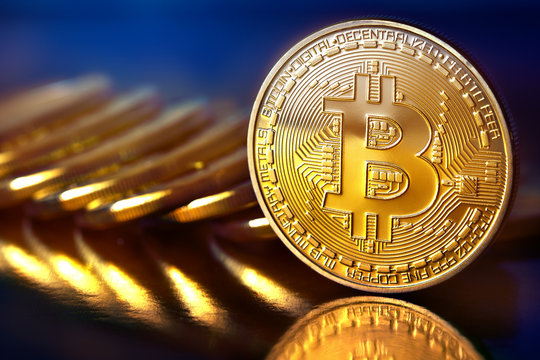 Photo Golden Bitcoins (new virtual money ) Close-up on a blue background.