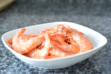 red lobster in white plate ready 
on the gray granite kitchen surface
