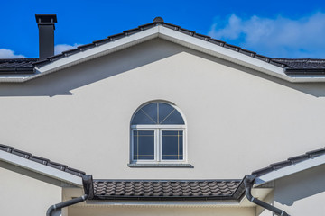Fototapeta na wymiar Moderne Fassade mit Giebel und weißem PVC Bogenfenster