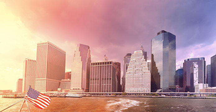 Sunset over Manhattan with American flag, New York, USA.