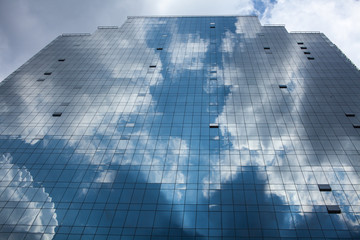 Plakat Abstract glass building reflecting clouds and blue sky