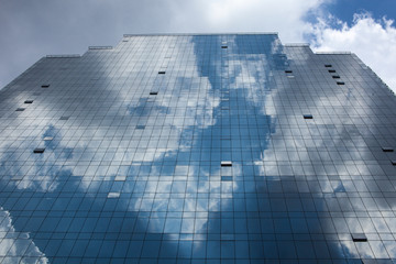Fototapeta na wymiar Abstract glass building reflecting clouds and blue sky