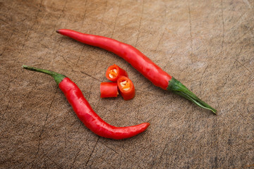 fresh and spicy cayenne with cup out sections on a wooden chop board