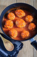 Meatballs with tomato sauce in black pan