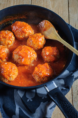 Meatballs with tomato sauce in black pan