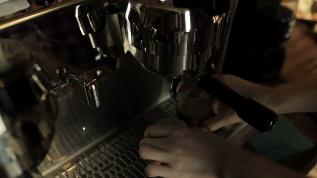 Barista prepares espresso machine before preparing coffee.