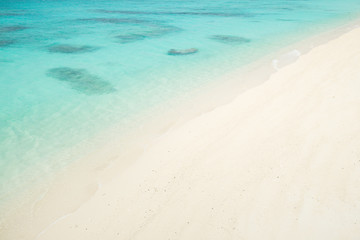 Fototapeta na wymiar Tropical paradise island beach lagoon and white sand beach full of beautiful clear blue turquoise water in Amami Oshima, Kagoshima, Okinawa, Tropical Japan during Summer vacation