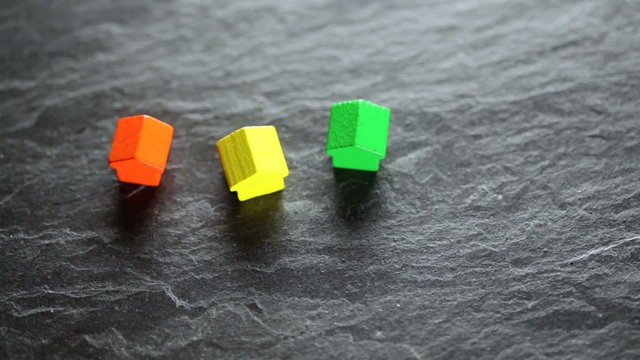 Putting coloured toy houses randomly on a plate of schist
