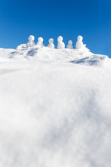 Fototapeta na wymiar Kleine Schneemänner auf einem Schneeberg mit Textfreiraum