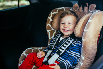 Adorable baby boy in safety car seat.