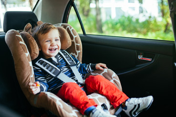 Adorable baby boy in safety car seat.