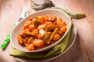 pasta with artichoke and tomatoes sauce, selective focus