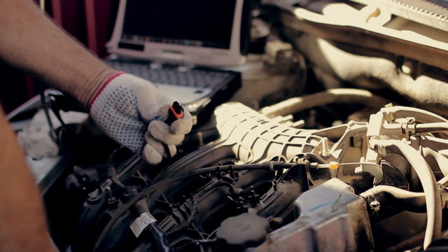 Car  service, computer diagnostics: mechanic looks for errors in