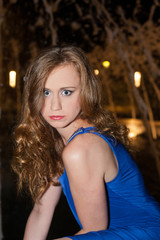 Oberkörperaufnahme Portrait der jungen Frau mit roten Haaren trägt hell Blaues elegantes Kleid und starrte mit großen Augen in die Kamera bei Nacht