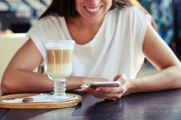 woman sitting in cafe with smartphone