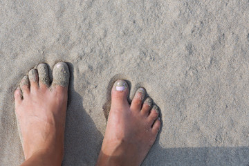 Women's feet in the sand, sand beach of Hendaye, France. summer beach hobby. Fun on the water.