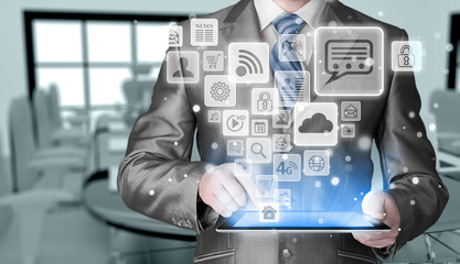 Obraz premium Business man using tablet PC with social media icon set