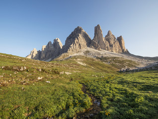 Naklejka premium Mountains Panorama of the Dolomites at Sunrise with flowers in f
