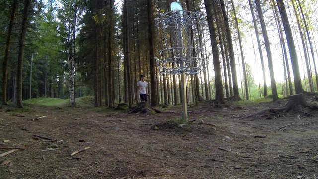 Disc golf player misses a putt throw touching the basket chains