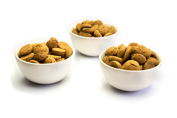 Three white dishes filled with kruidnoten