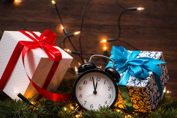 Christmass tree, gifts, lights and clock over the wooden wall