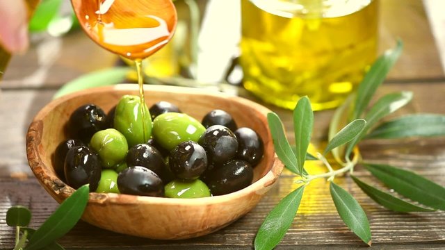 Olives and pouring olive oil. Extra virgin olive oil