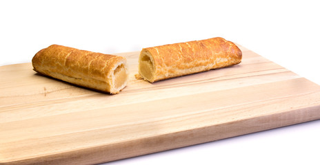 Two pieces of an almond bar on a wooden plate