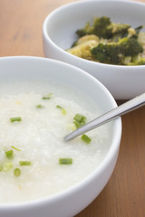 porridge and stir fried vegetable  in white bowl on wooden table