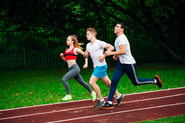 Obraz premium Running young people at stadium track
