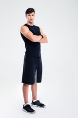 Serious fitness man standing with arms folded