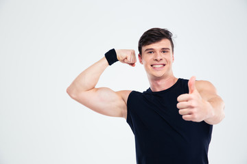 Fitness man showing his biceps and thumb up