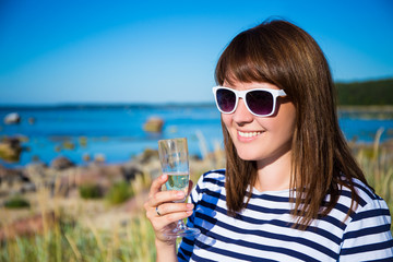 portrait of beautiful woman with glass of champagne on the beach