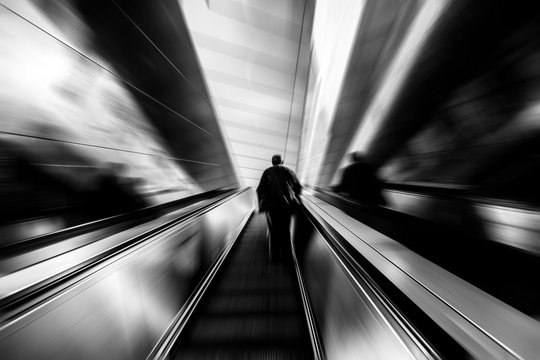 Silhouette Of Man Going Up On Escalator
