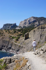 Naklejka premium Мужчина идет по тропе Голицына. Поселок Новый Свет. Крым.