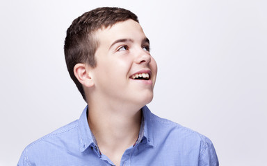 Fototapeta premium Daydreaming boy looking up against grey background