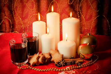 Candles with christmas balls, cookies, mulled wine and spices