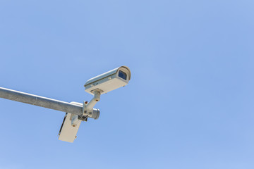 Two security camera on blue sky