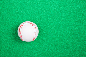 A white used baseball on the fresh green grass