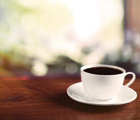Cup of coffee on table on light background
