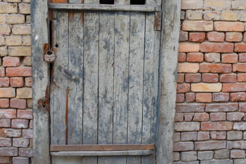 Decrepit and old door and brick wall in the evening