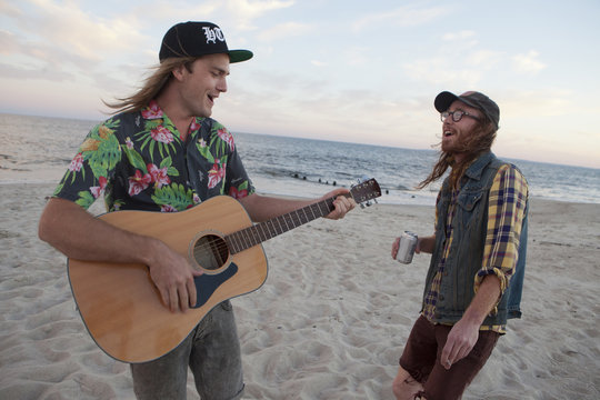 Friends playing music together on a beach