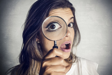 Beautiful girl using magnifying glass