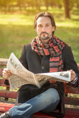 Man reading newpaper in the park