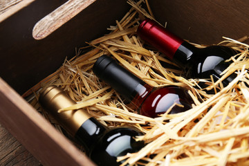 Three wine bottles in box with straw