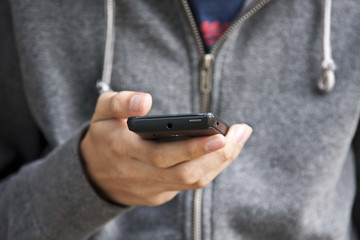 young man's hand holding the mobile phone