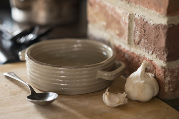Baking Dish, Spoon, and Garlic Cloves on Wooden Counter