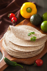 whole wheat tortillas on wooden board and vegetables
